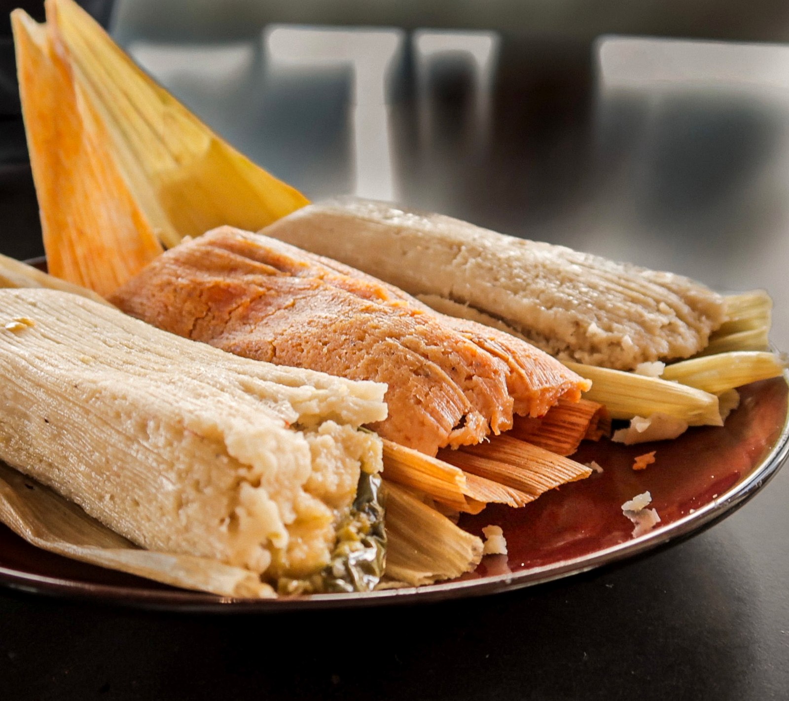 A plate of three handmade tamales, fresh from the steamer